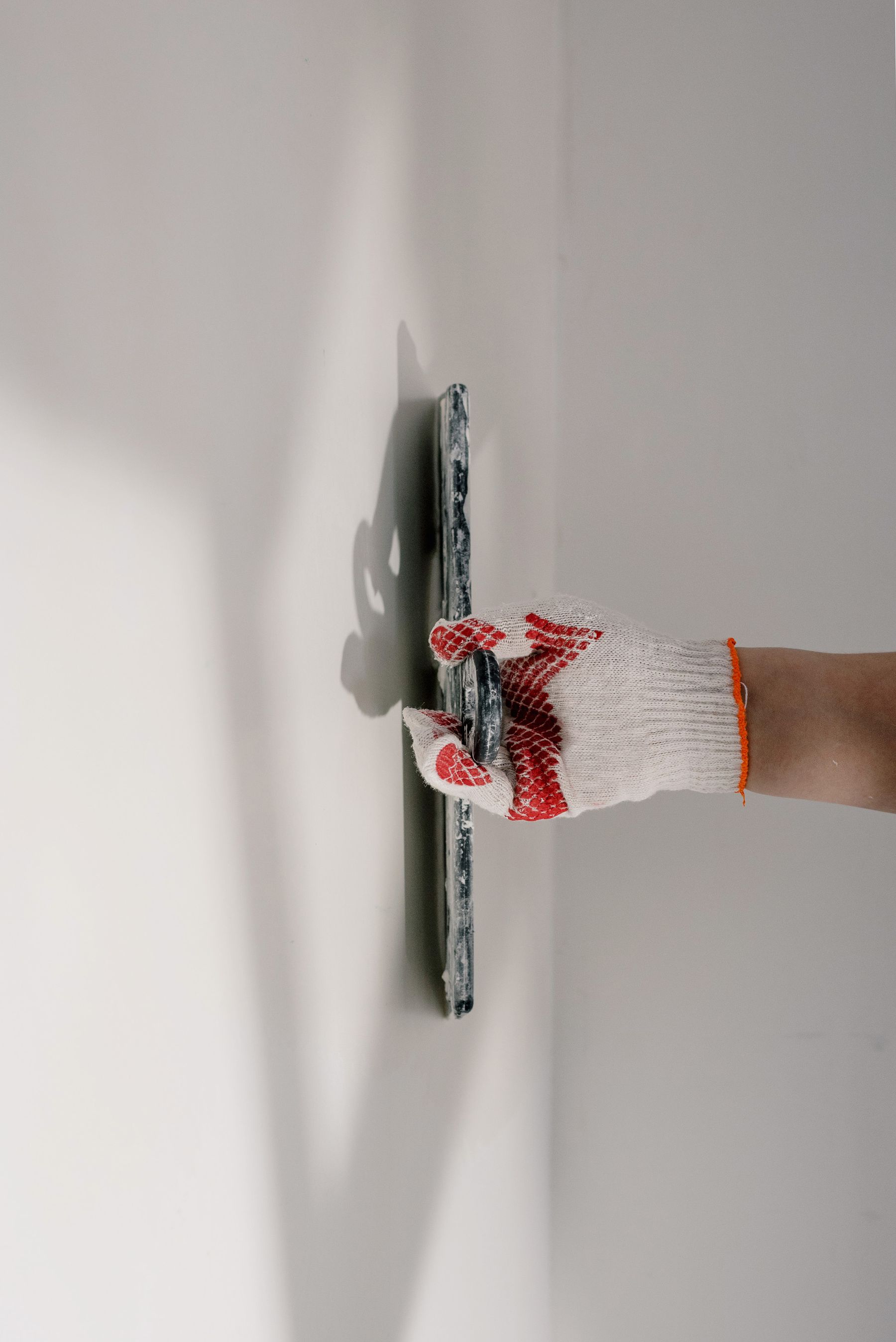 Professionelle Glättung einer verputzten Wand mit der Traufel